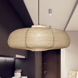 Wide disc paper lantern lit above a kitchen in a dark room