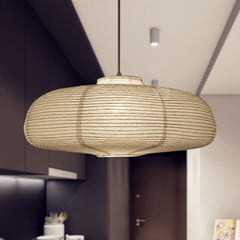 Wide disc paper lantern lit above a kitchen in a dark room
