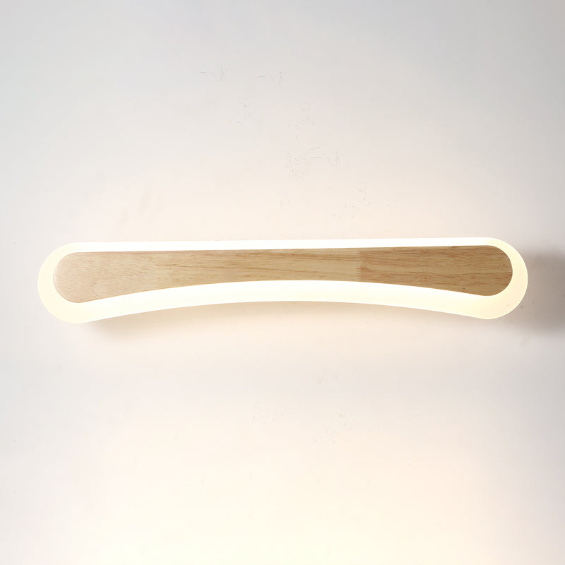 Curved wood and acrylic vanity light lit on a plain white wall