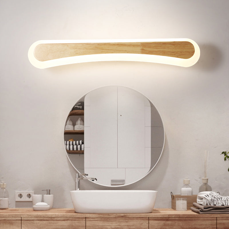 Curved wood vanity light lit above a round mirror and timber vanity