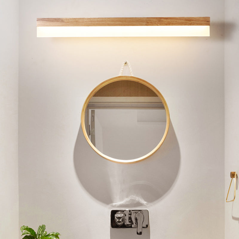 Straight wood vanity light lit above a round mirror and basin