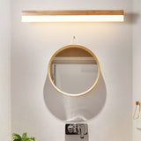 Straight wood vanity light lit above a round mirror and basin