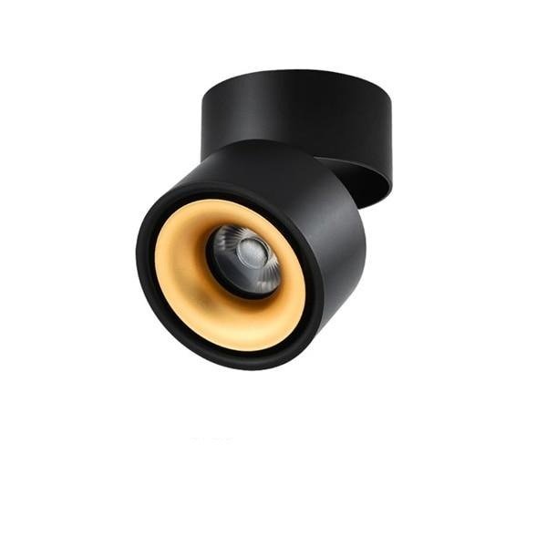 Black ceiling spotlight with a gold inner ring seen from the front