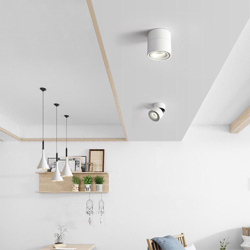 White ceiling spotlights mounted on a white ceiling above a dining area