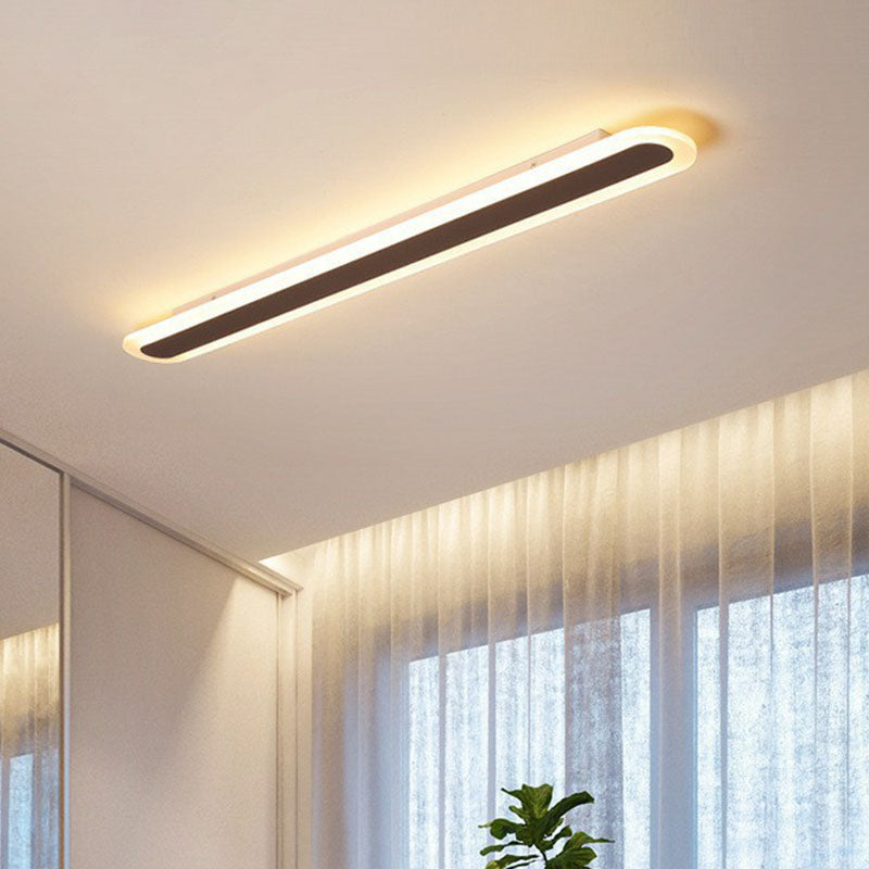 Coffee linear fixture above sheer curtains and a bright window