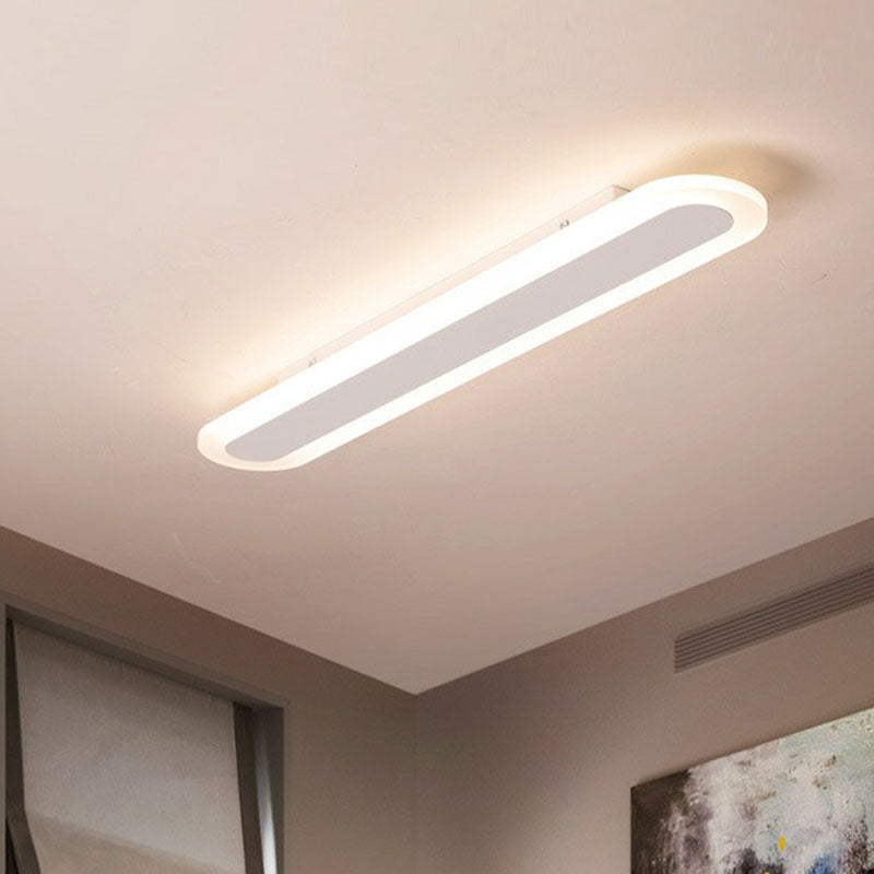 White linear flush mount seen at an angle on a plain ceiling