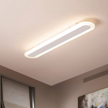 White linear flush mount seen at an angle on a plain ceiling