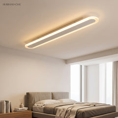 White linear ceiling fixture in a bedroom above a made bed