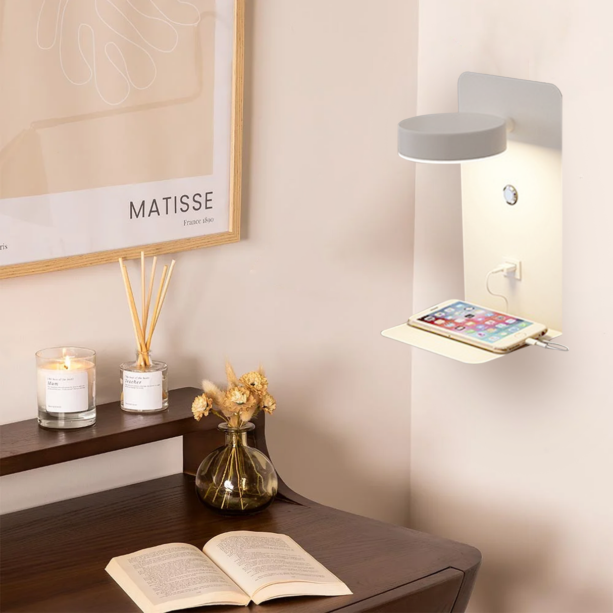 White wall lamp above a desk charging a phone by warm light
