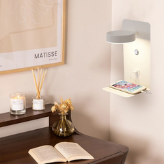 White wall lamp above a desk charging a phone by warm light