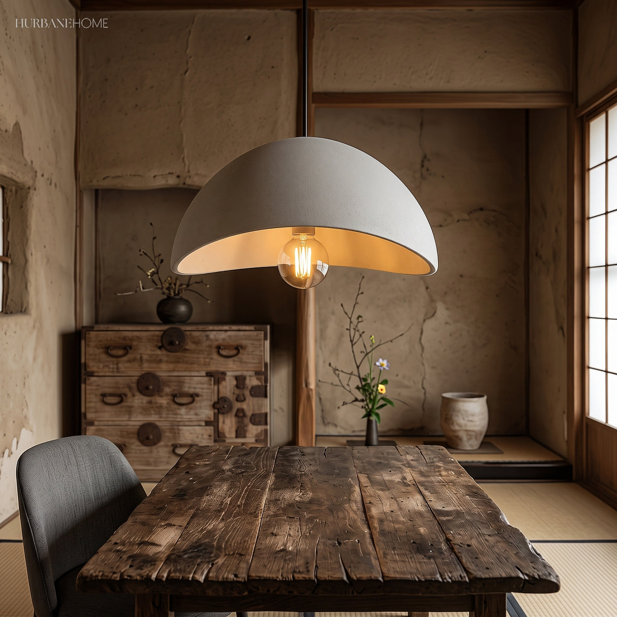 White pendant light with warm LED bulb above wooden dining table