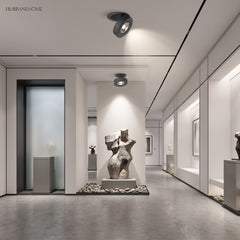 Black spotlight on a gallery ceiling lighting sculptures along a corridor
