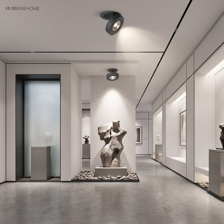 Black spotlight on a gallery ceiling lighting sculptures along a corridor