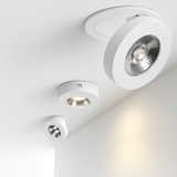 Three white spotlights tilted at different angles on a white ceiling