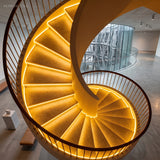 Spiral staircase with recessed strip lighting under every tread from above