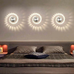 Three spiral wall lights casting white patterns above a bed