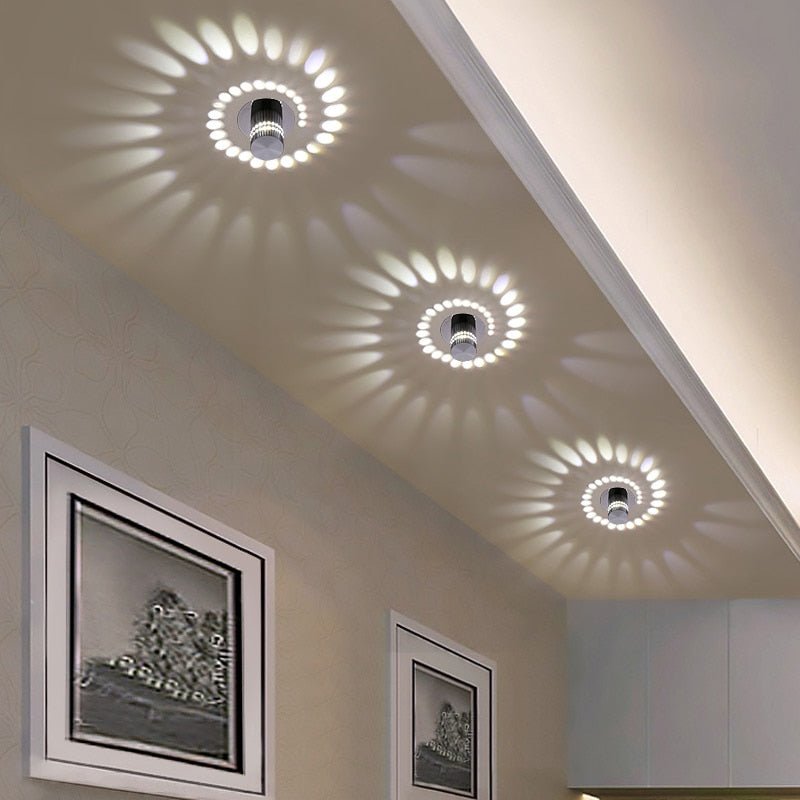 Three spiral effect lights casting white swirl patterns on a hallway ceiling