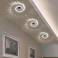 Three spiral effect lights casting white swirl patterns on a hallway ceiling