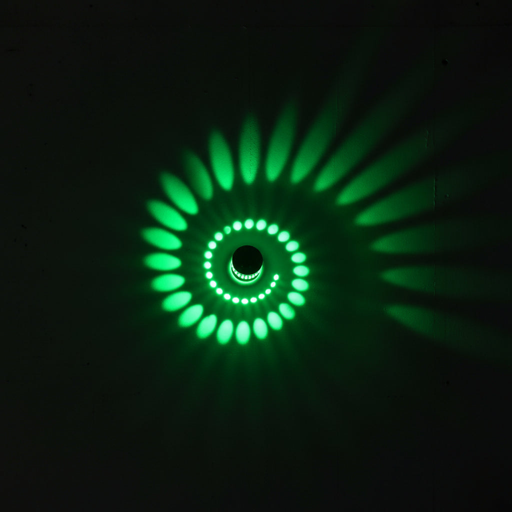 Close view of a green spiral pattern thrown across a wall