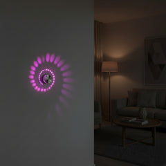 Close view of a pink spiral pattern thrown across a wall