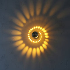Close view of a yellow spiral pattern thrown across a wall