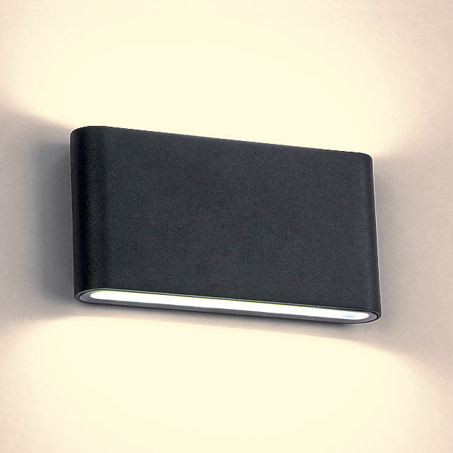 Black sconce studio shot with warm light spilling up and down