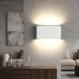 White LED wall sconce glowing above a console in a living room