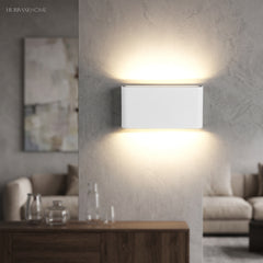 White LED wall sconce glowing above a console in a living room