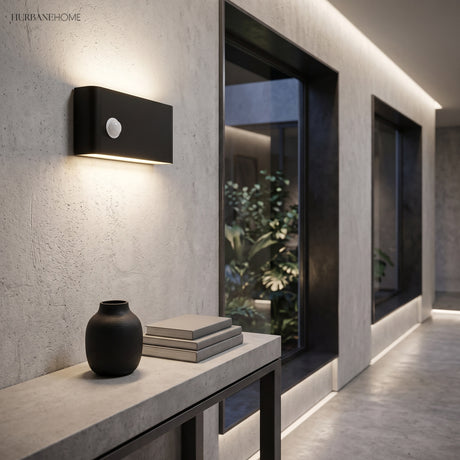 Black LED wall sconce lighting a concrete corridor at night