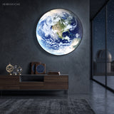 Large illuminated Earth sconce mounted above a dark timber console
