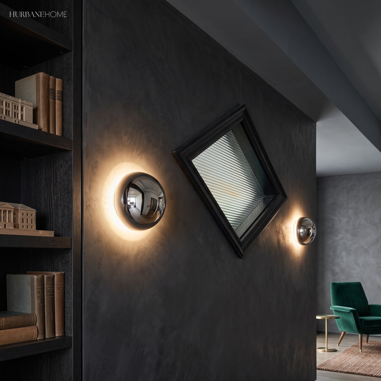 Two mirrored dome sconces lit on a dark bookshelf wall