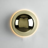 Large gold dome sconce lit on a white wall showing the halo ring