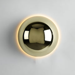 Large gold dome sconce lit on a white wall showing the halo ring