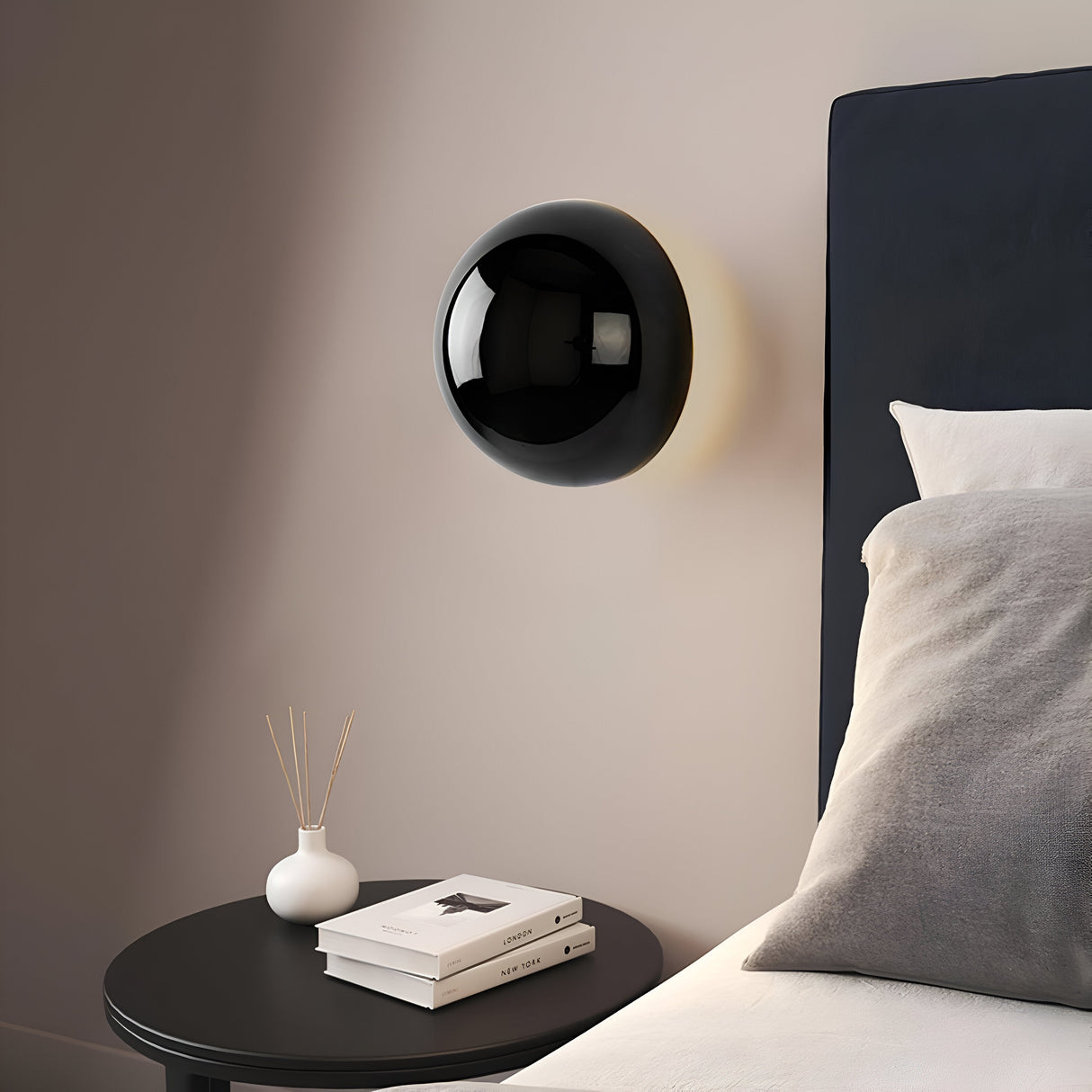 Gold dome sconce lit on a white wall with a strong halo ring