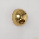 Silver dome sconce lit on a wall beside a large potted plant