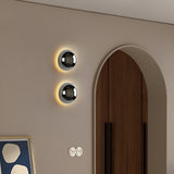 Two silver dome sconces on a beige wall beside an arched doorway