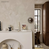 Silver mirrored dome sconce lit above a white fireplace mantel