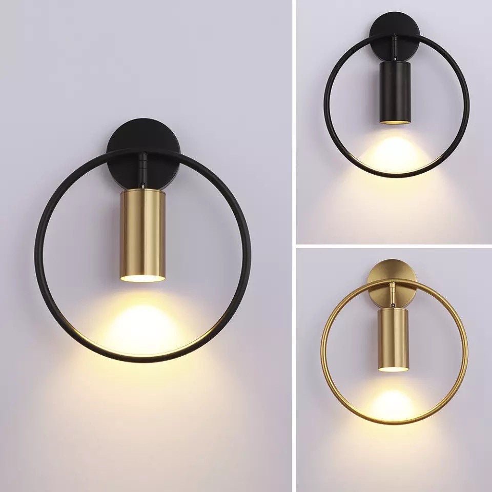 Black and brass ring wall sconces lit with the spot inside the hoop
