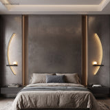 Two black arc wall lights framing a bed in a dark modern bedroom
