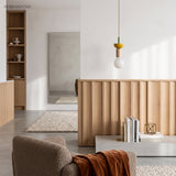 Yellow dome and ash wood pendant light hanging in a bright minimalist room