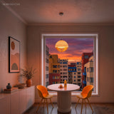 Warm-lit dome pendant with amber rings over a round dining table and two orange chairs