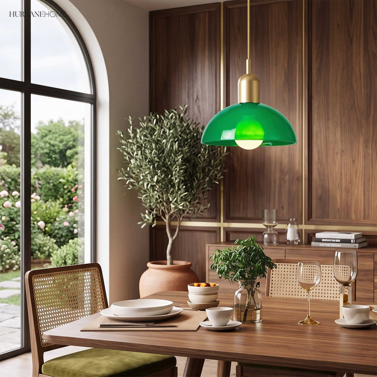 Green glass bowl pendant light above a wooden dining table set for a meal