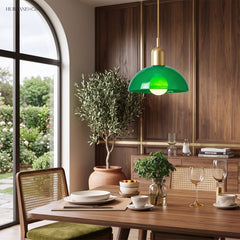 Green glass bowl pendant light above a wooden dining table set for a meal
