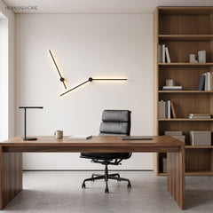 Two black linear wall lights forming an angled line above a walnut office desk