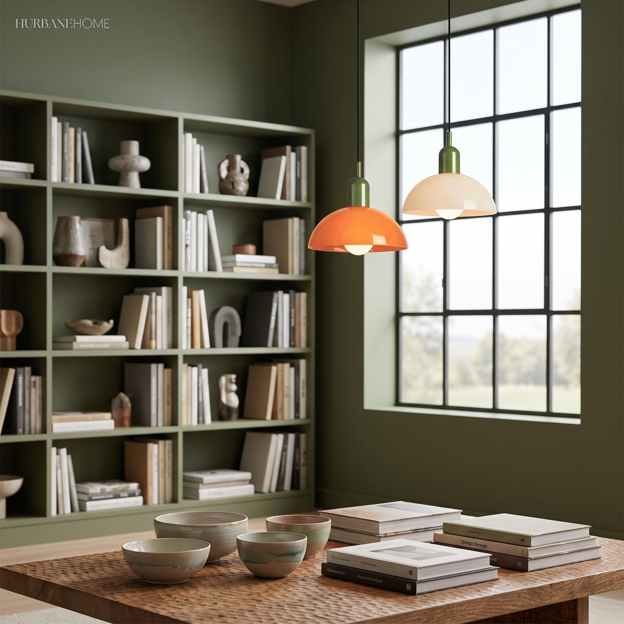 Orange and cream glass pendant lights by a window in a green study