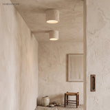 Pair of cream flush mount ceiling lights in a minimalist plaster corridor