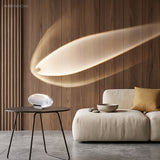 Modern glass table lamp casting sunset light across a living room wall