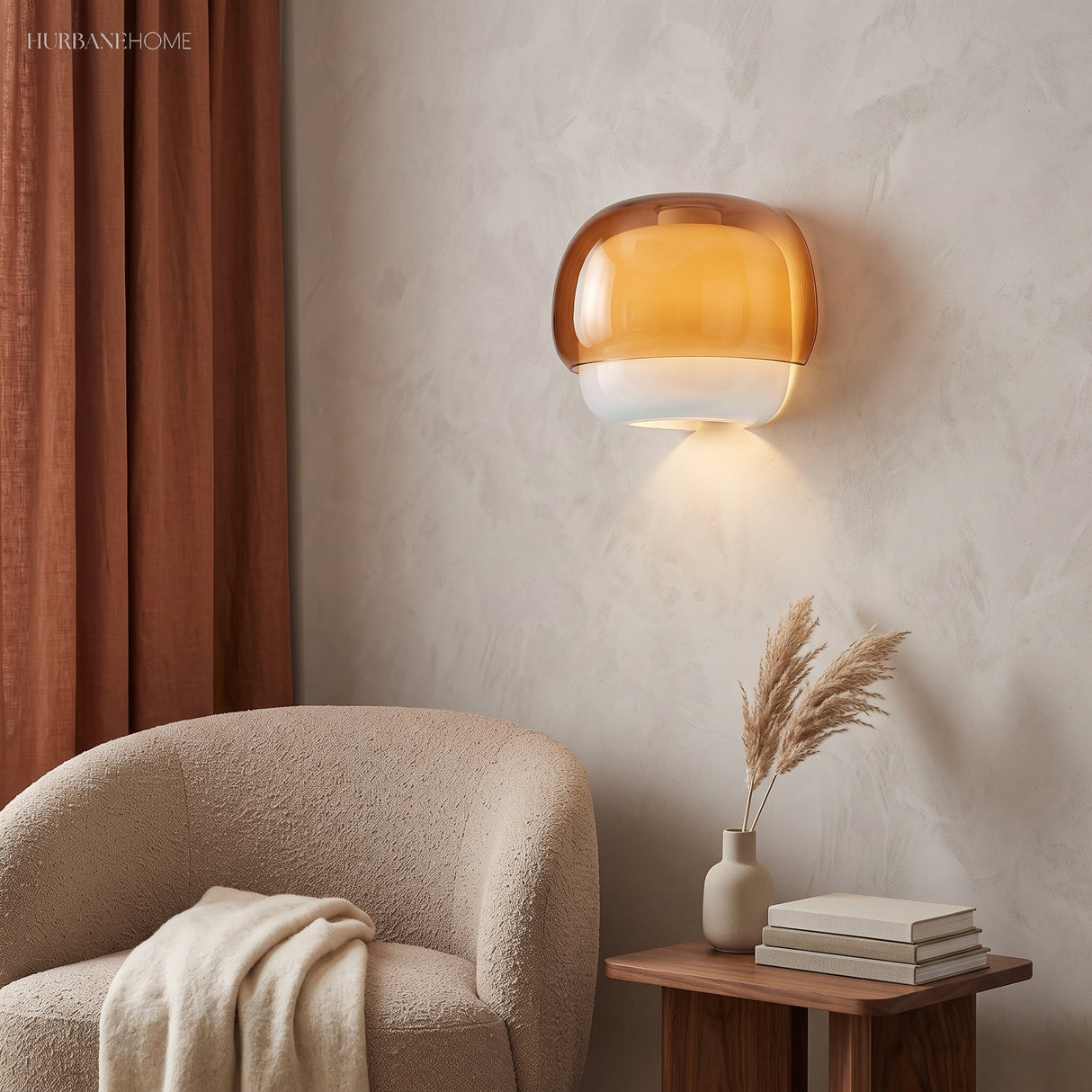 Orange glass sconce casting warm light above a boucle armchair and side table