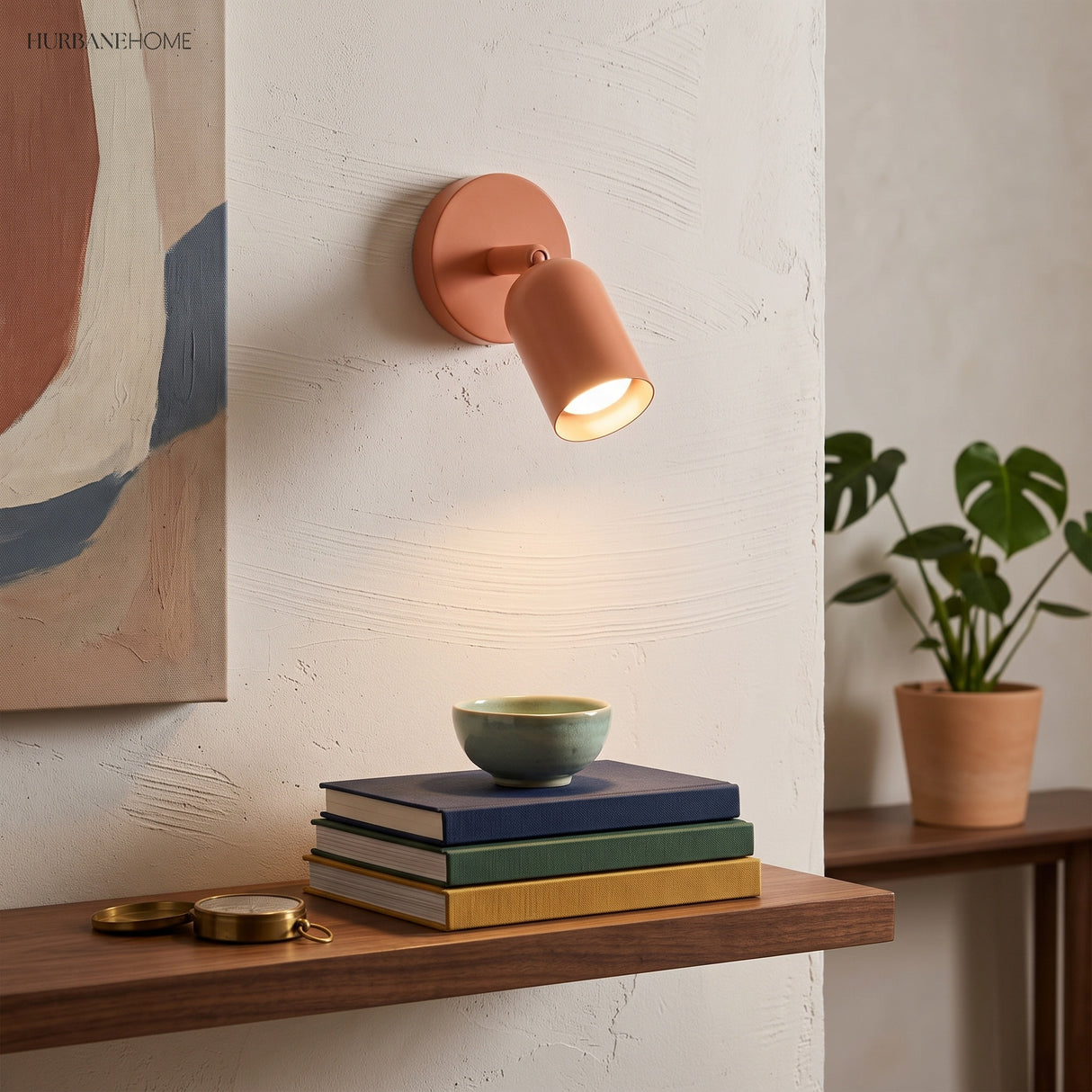 Terracotta bedside wall light casting a warm beam onto a shelf of stacked books