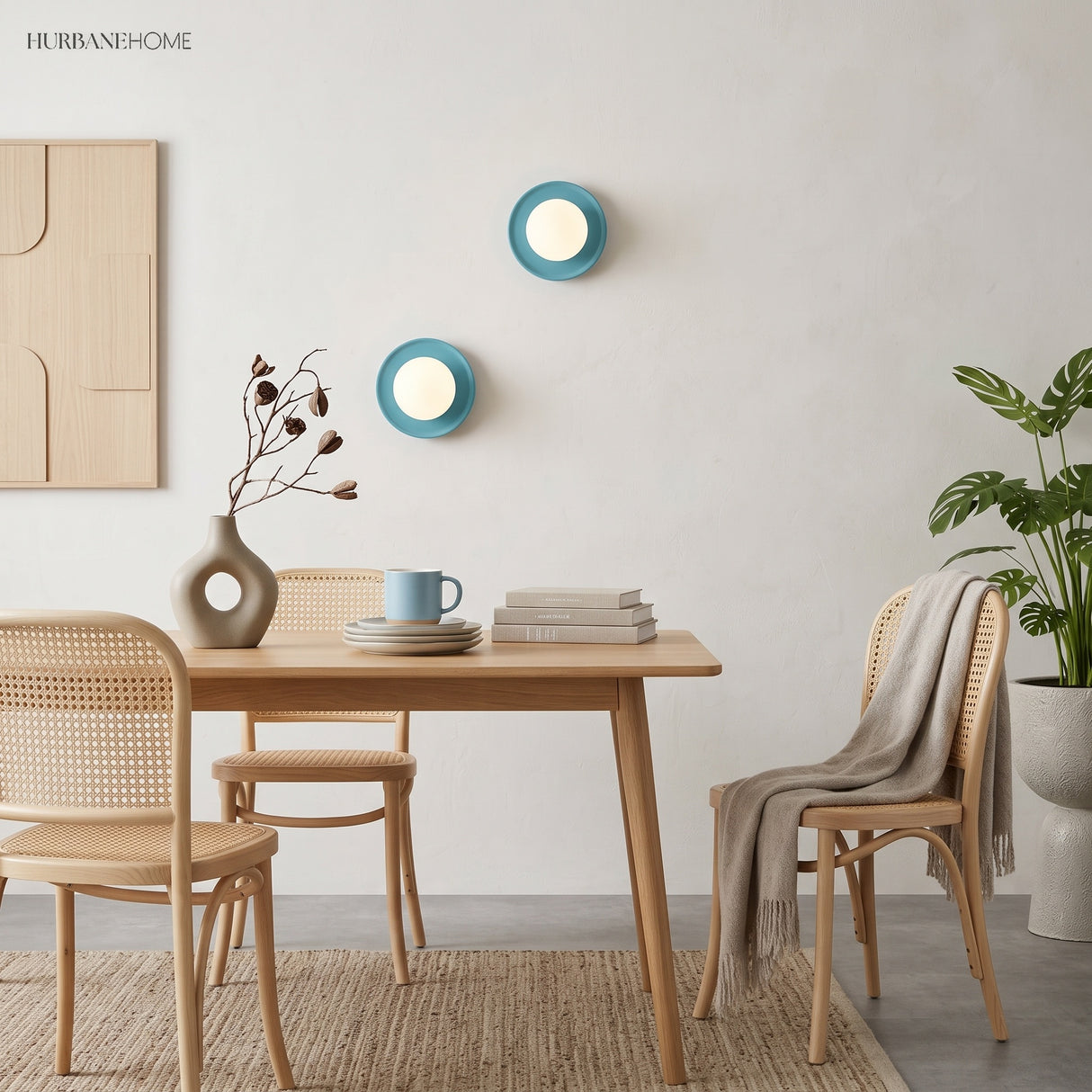 Two blue orb wall sconces above a dining table with rattan chairs